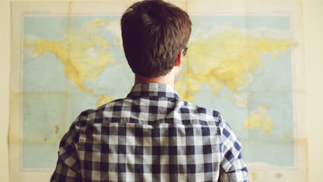 Young-tourist-man-looking-at-world-map
